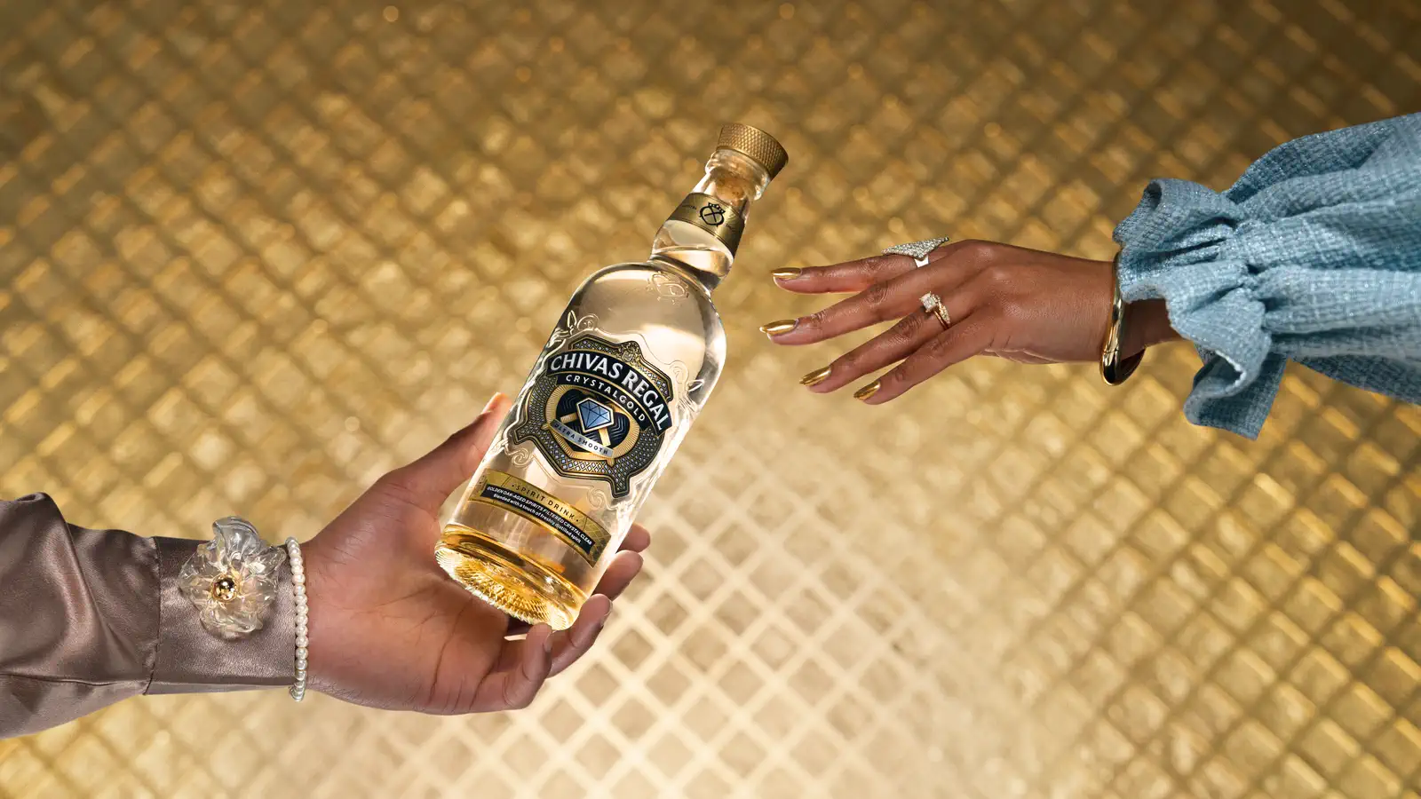 Una botella de Chivas Regal Crystalgold pasando de mano en mano